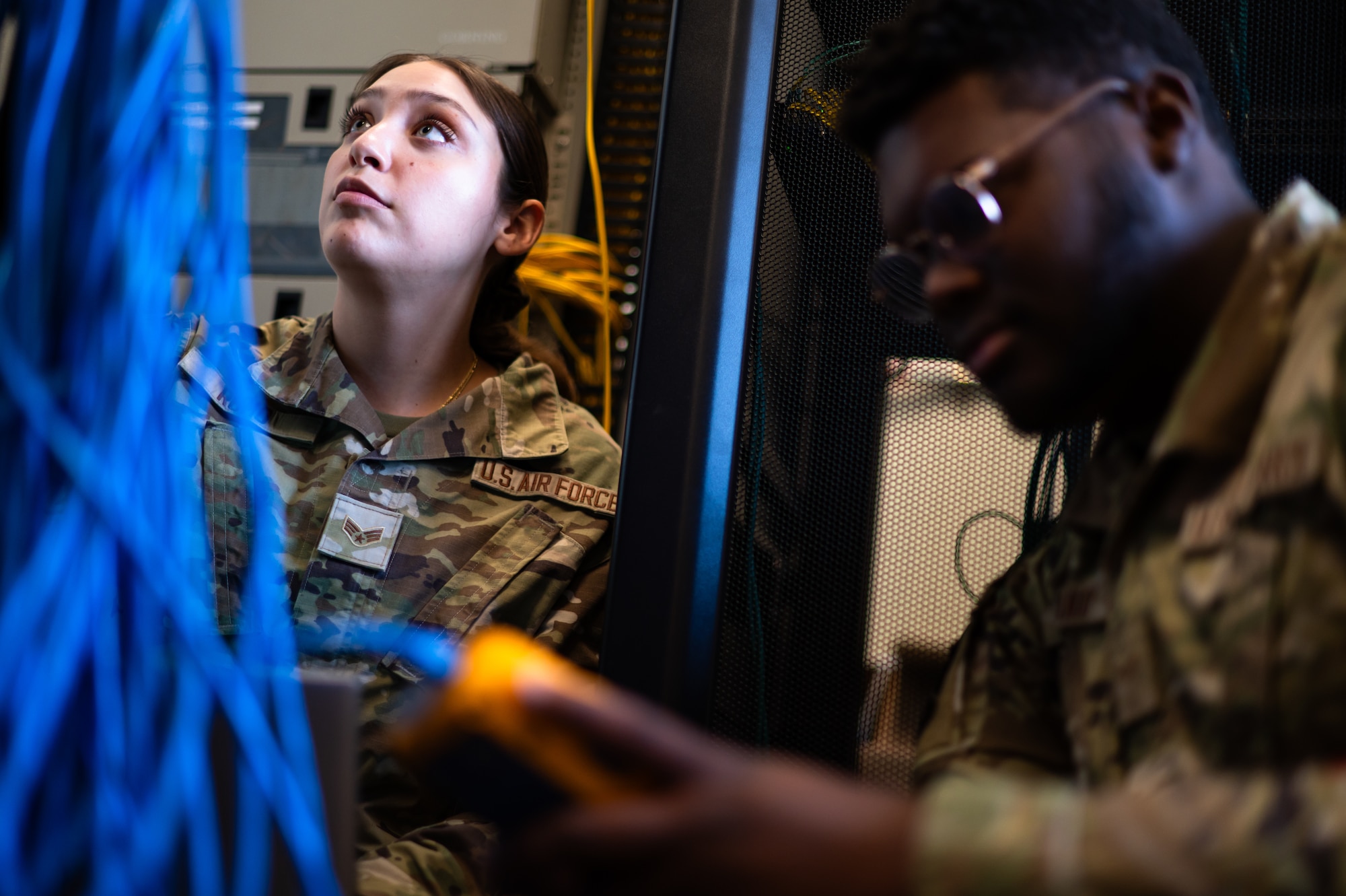 U.S. Air Force Senior Airman Isabella Romo, left, and Airman 1st Class Cameron Ganaway, 7th Communications Squadron cyber defense operations technicians, look over equipment at Dyess Air Force Base, Texas, June 26, 2024. In a nine-month process, the 7th CS enhanced base readiness by replacing obsolete network hardware, resulting in increased communication speed and the ability to handle modern threats. (U.S. Air Force photo by Airman 1st Class Jade M. Caldwell)