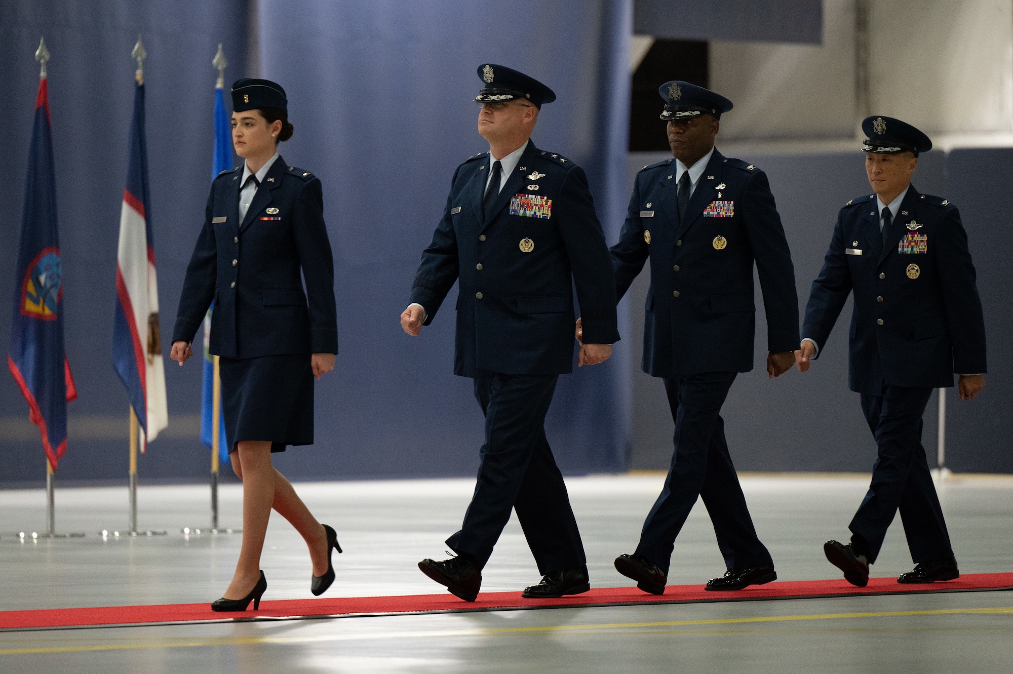U.S. Air Force 2nd Lt. Sara Rulli, Maj. Gen. Daniel A. DeVoe, Col. Todd E. Randolph, and Col. Jun S. Oh walk toward the stage
