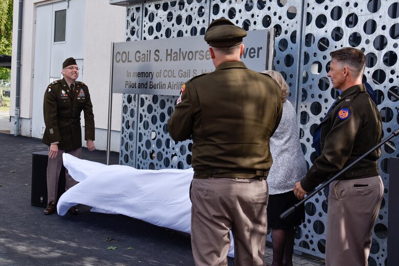 U.S. Army Garrison Wiesbaden Commander Col. David Mayfield; daughter of the late Col. Gail S. Halvorsen Denise Williams; U.S. Army Corps of Engineers, Europe District Commander Col. Dan Kent and Air Traffic Controller Dirk Schulz gather to unveil the sign at the newly dedicated Col. Gail S. Halvorsen Tower on the Clay Kaserne portion of the U.S. Army Garrison Wiesbaden June 15, 2024. Members of the U.S. Army Garrison Wiesbaden community, U.S. Army Corps of Engineers personnel and several Berlin Airlift time witnesses and time witness family members joined together for the ceremony officially dedicating the new air traffic control tower in honor of the late Berlin Airlift “Candy Bomber.” (U.S. Army photo by Chris Gardner)