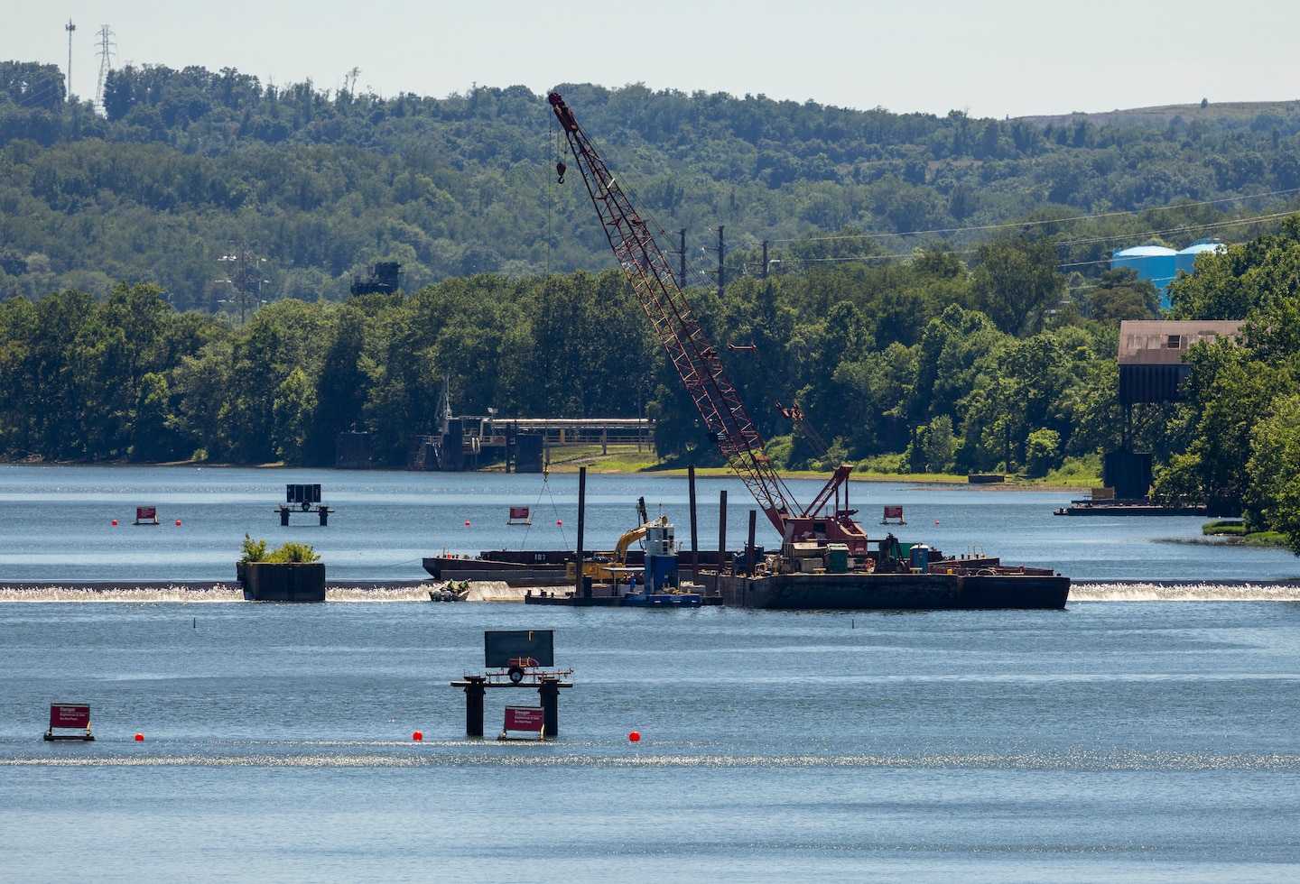 A contractor for the U.S. Army Corps of Engineers Pittsburgh District prepares the fixed-crest dam at the Monongahela River Locks and Dam 3 for demolition near Elizabeth, Pennsylvania, July 2, 2024.