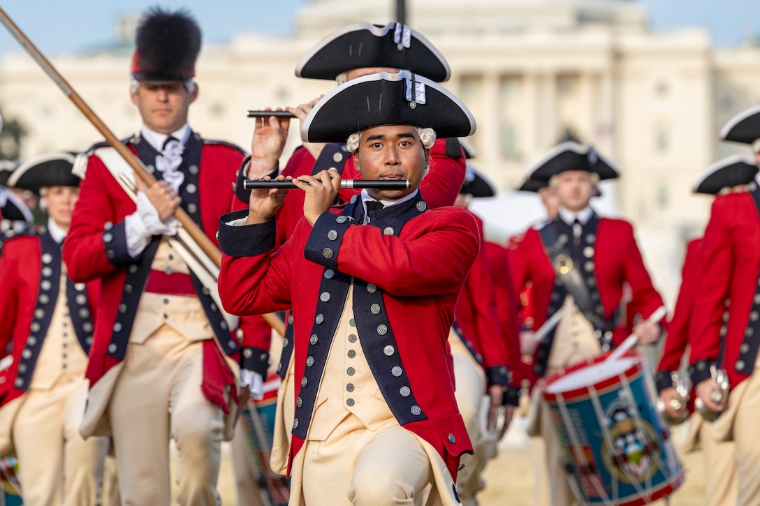 Soldiers in ceremonial dress perform in front of the blurred U.S. Capitol.