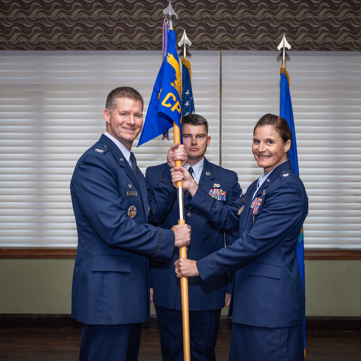 Col. Richards and Lt. Col. Amy Justus pose for a photo while holding the unit guidon