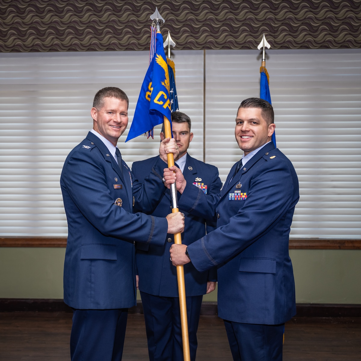 Col. Richards and Maj. Moore pose for a photo while holding the unit guidon