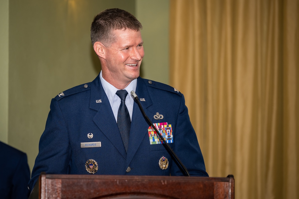 Col. Richards laughs while giving a speech behind a podium