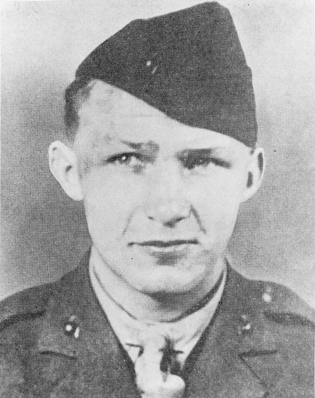 A man in uniform and cap poses for a photo.