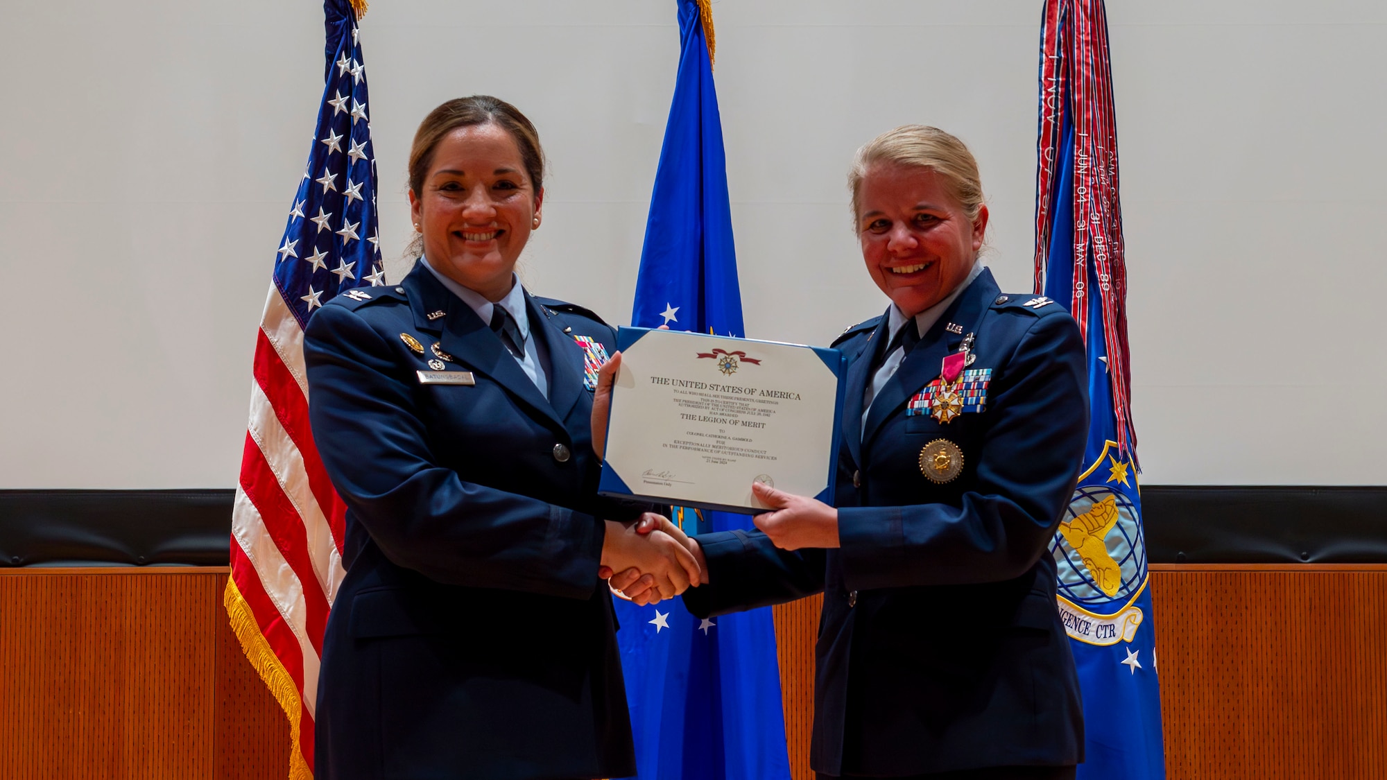 Col. Ariel Batungbacal, left, presents Col. Catherine Gambold with a Legion of Merit at Wright-Patterson Air Force Base.