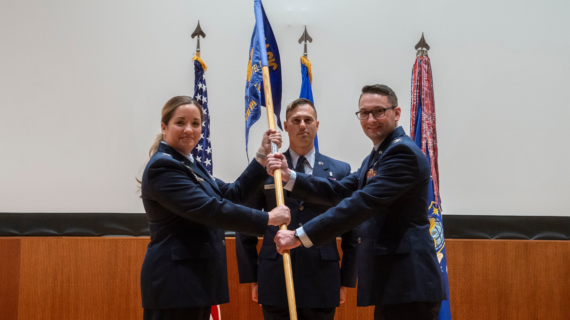 Col. Ariel Batungbacal passes the guidon to Col. Ryan Skaggs during a change of command ceremony.