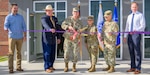 Joint Base San Antonio and 502nd Air Base Wing commander, Brig. Gen. Russell Driggers, prepares to cut a ribbon during a ceremony June 27, 2024, to celebrate the official opening of the new Unaccompanied Enlisted Personnel Housing facility on JBSA-Fort Sam Houston, Texas. (U.S. Air Force photo by James Nelson)