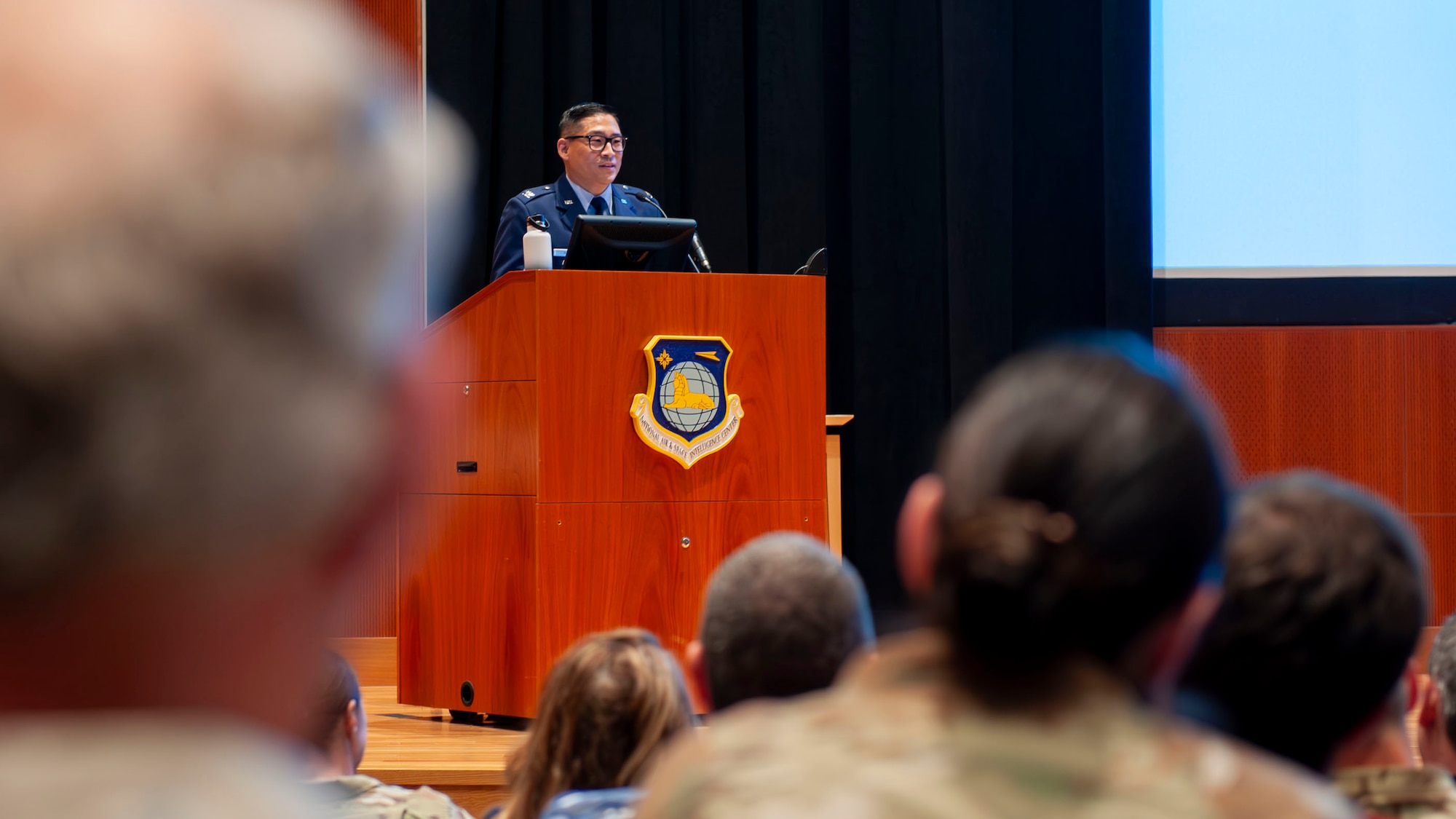 Col Noh standing at Podium