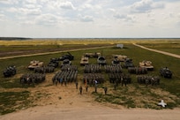 Soldiers of the Forward Land Forces Battle Group Poland made up 2nd Battalion, 12th Cavalry Regiment, 1st Armored Brigade Combat Team, 1st Cavalry Division, along with 13th Croatian Contingent “Iron Storm,” Romanian Air Defense “Sky Guardians” and United Kingdom Eagle Troop pose for a group photo in Bemowo Piskie Training Area, Poland, June 28, 2024. The 1st Cavalry Division’s mission is to engage in multinational training and exercises across the continent, strengthening interoperability with NATO allies and regional security partners, which provides competent and ready forces to V Corps, America’s forward-deployed corps in Europe. (Photo by Sgt. Cecil Elliott II)