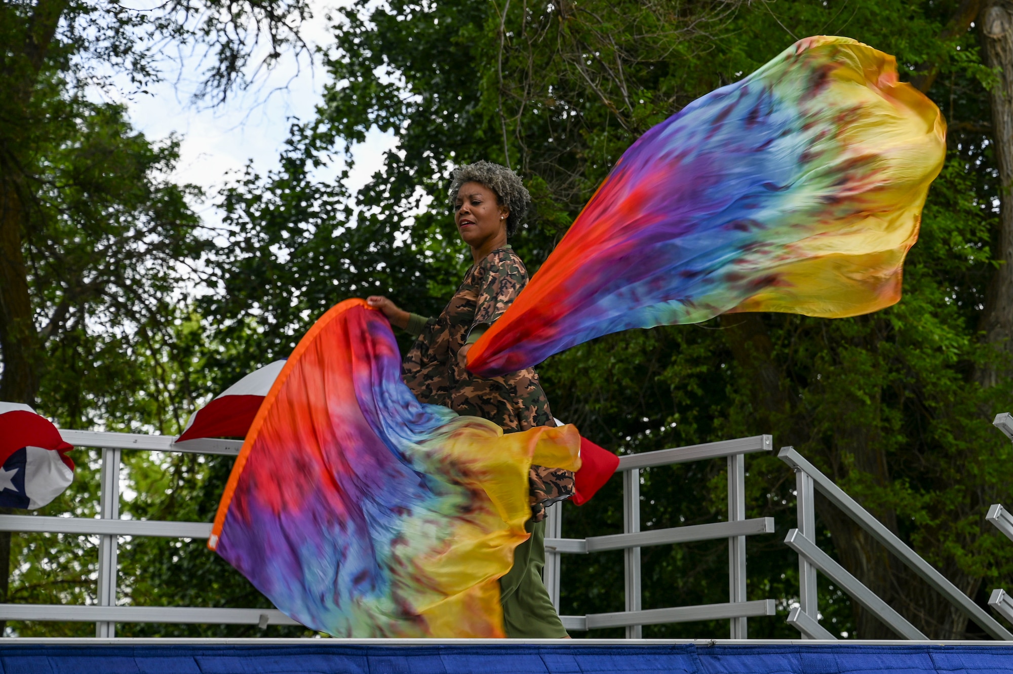A woman dances on a stage with colorful ribbons.