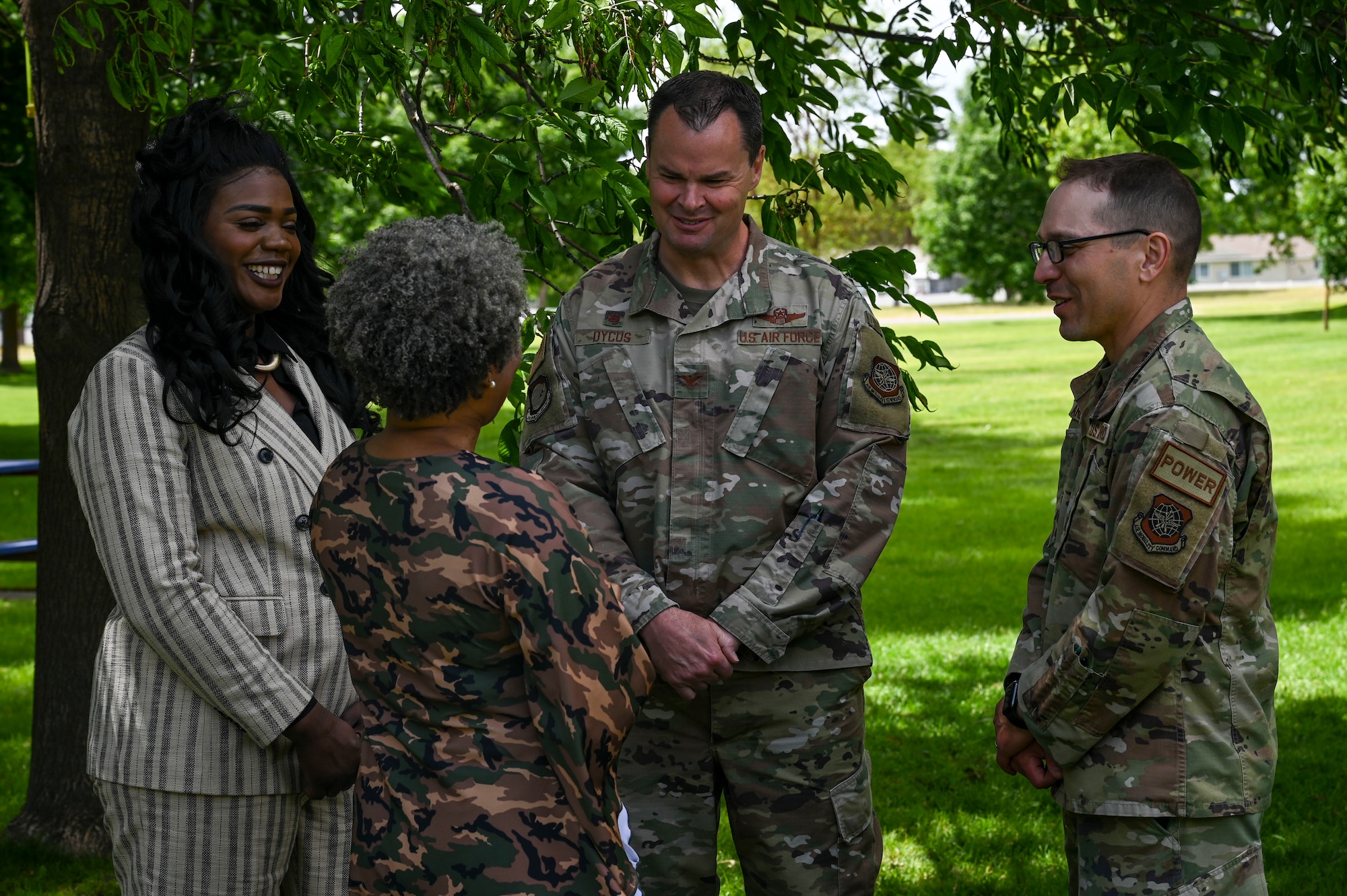 Two women speak to two Airmen.