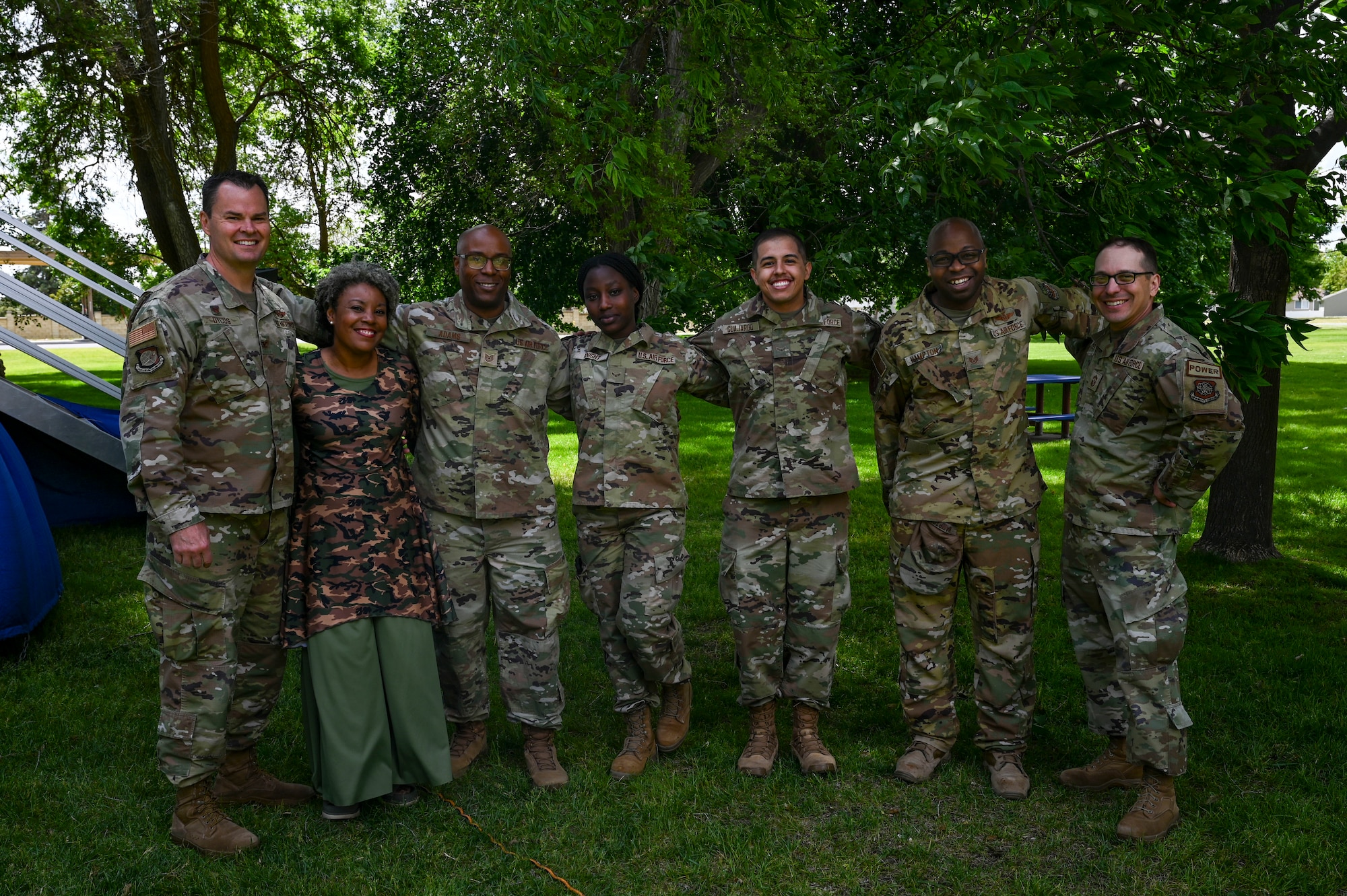 A civilian poses with a group of Airmen.