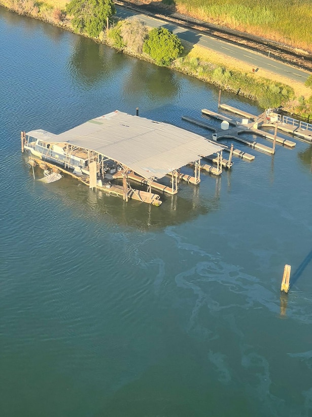 An aerial view of a sheen is seen in a waterway, taken from a Coast Guard helicopter.