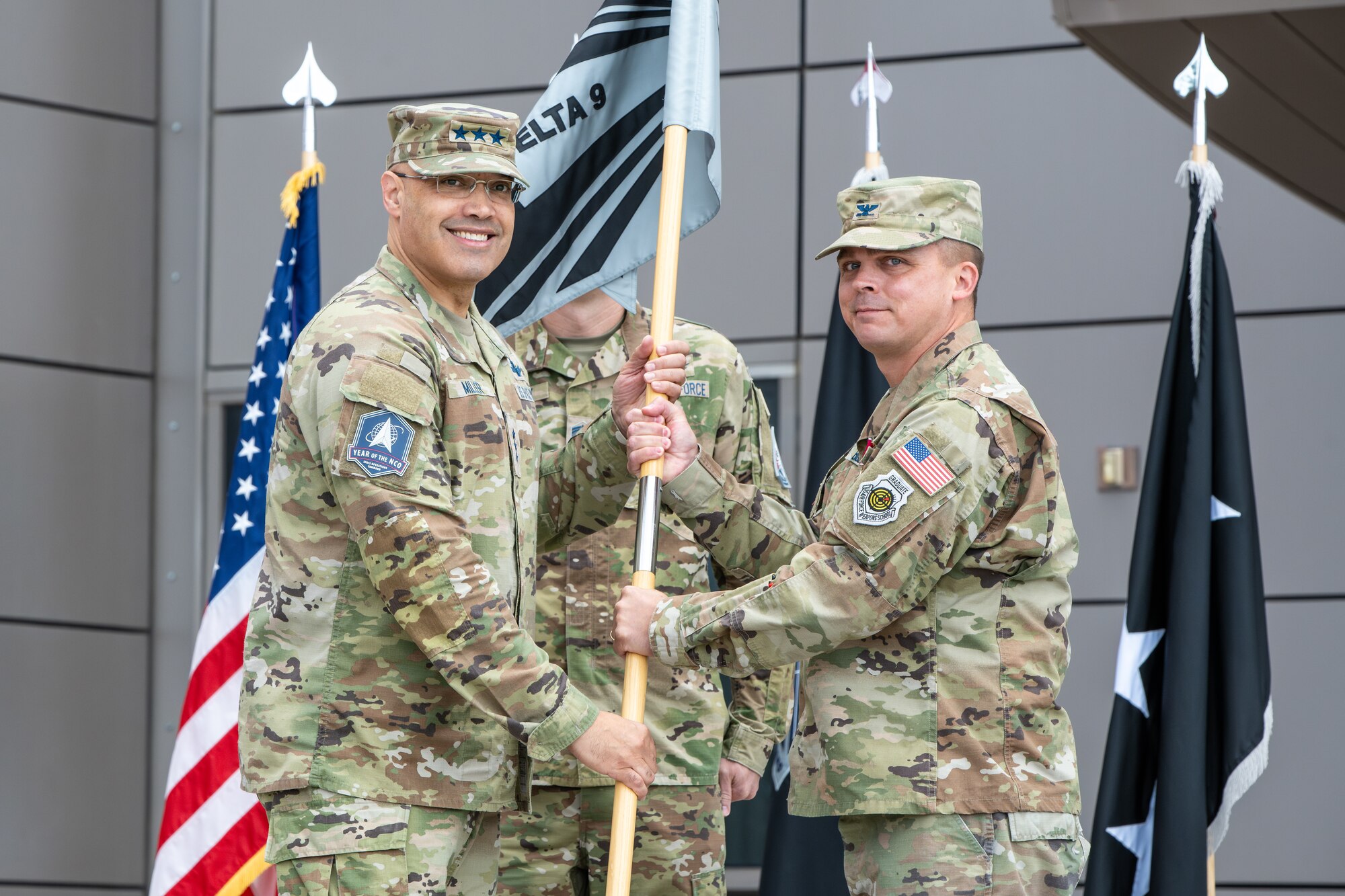 Uniformed members hold guidon during the change of command of space Delta 9.