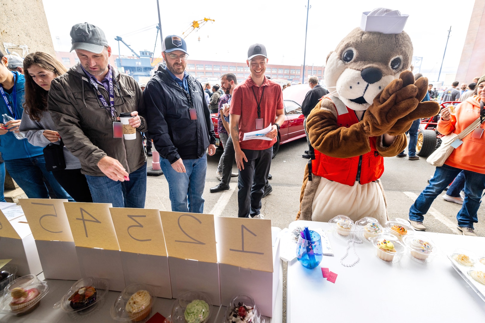 Ollie the Otter visits the 'Cupcake Wars' booth June 27, 2024, during the command sponsored "Pathway to Safety" event at Puget Sound Naval Shipyard & Intermediate Maintenance Facility in Bremerton, Washington.