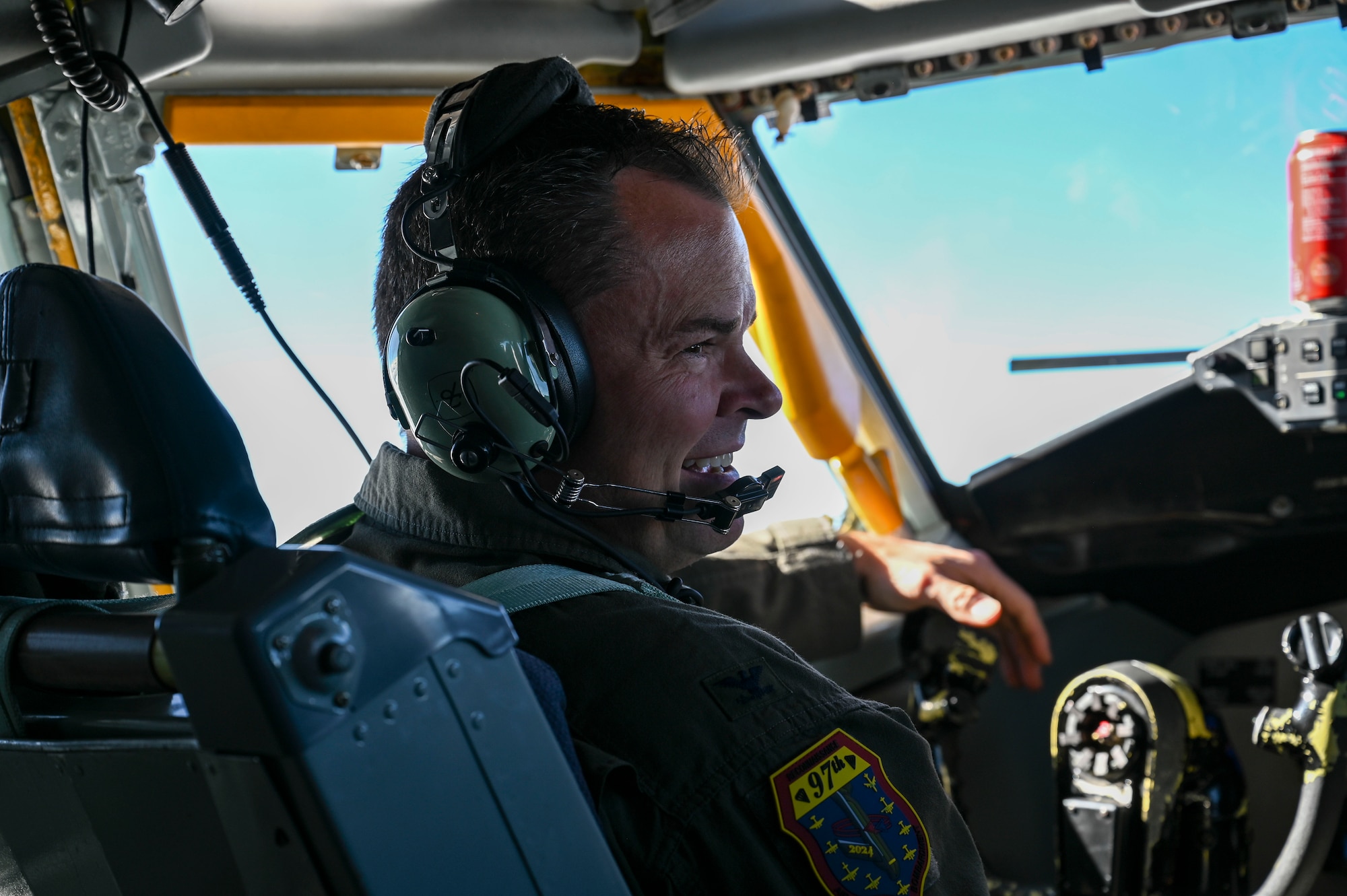 A pilot smiles in the cockpit of a jet.