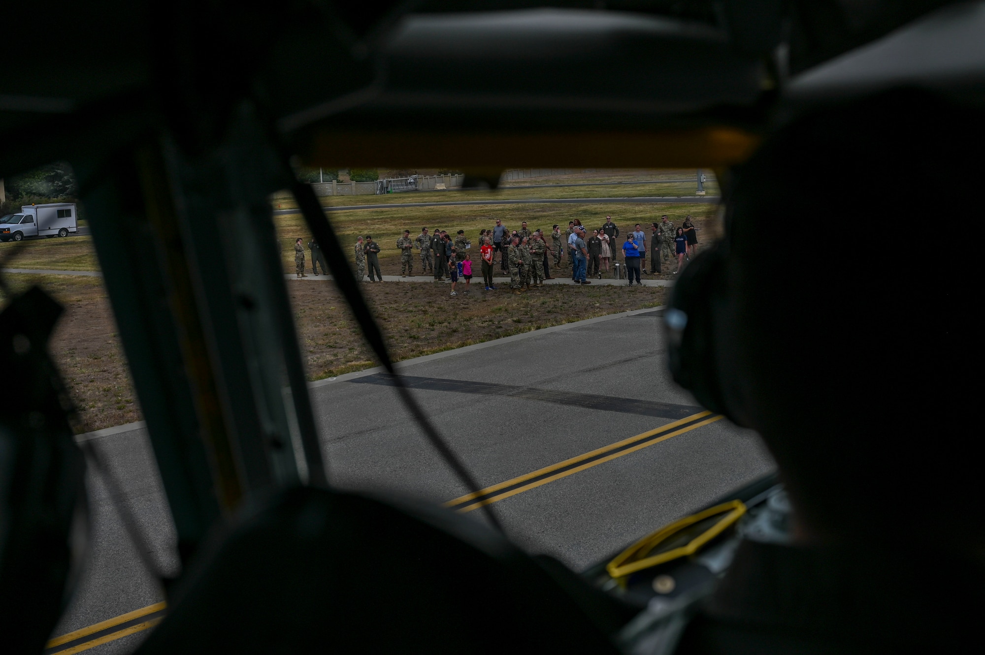 A pilot looks out the window of a cockpit at his friends and family.