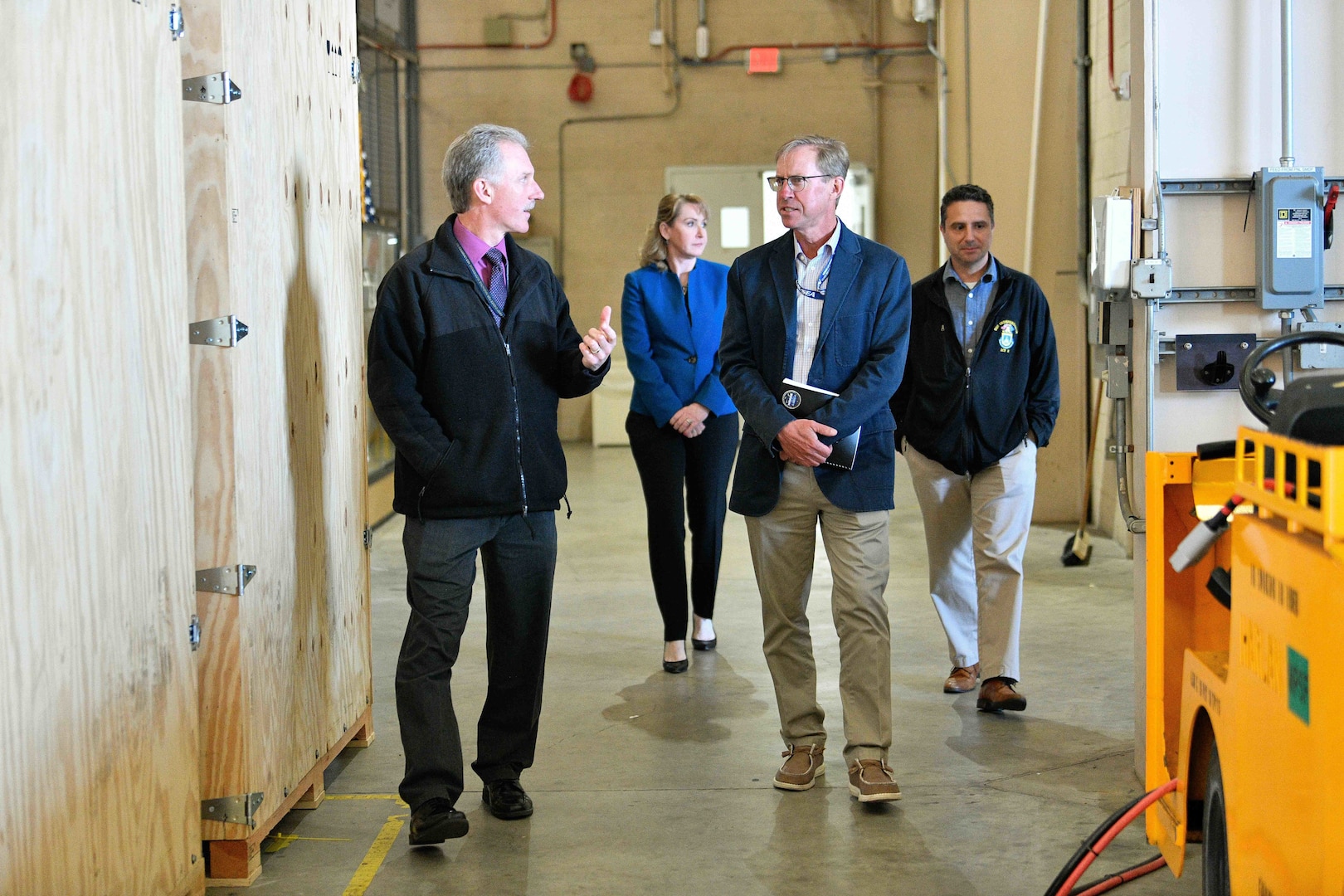 Gene Scampone, NSWC Port Hueneme Division’s (NSWC PHD) Mission Package Support Facility (MPSF) manager (front left), takes Dr. Peter Adair, technical director of NSWC Panama City Division (front right) on a tour of the MPSF on April 30, along with Susan Vargas, NSWC PHD deputy chief of staff (behind left), and Andrew Payor, MPSF sustainment principal assistant program manager. The MPSF provides assembly and sustainment to littoral combat ship mission packages. (U.S. Navy photo by Dana Rene White/Released)