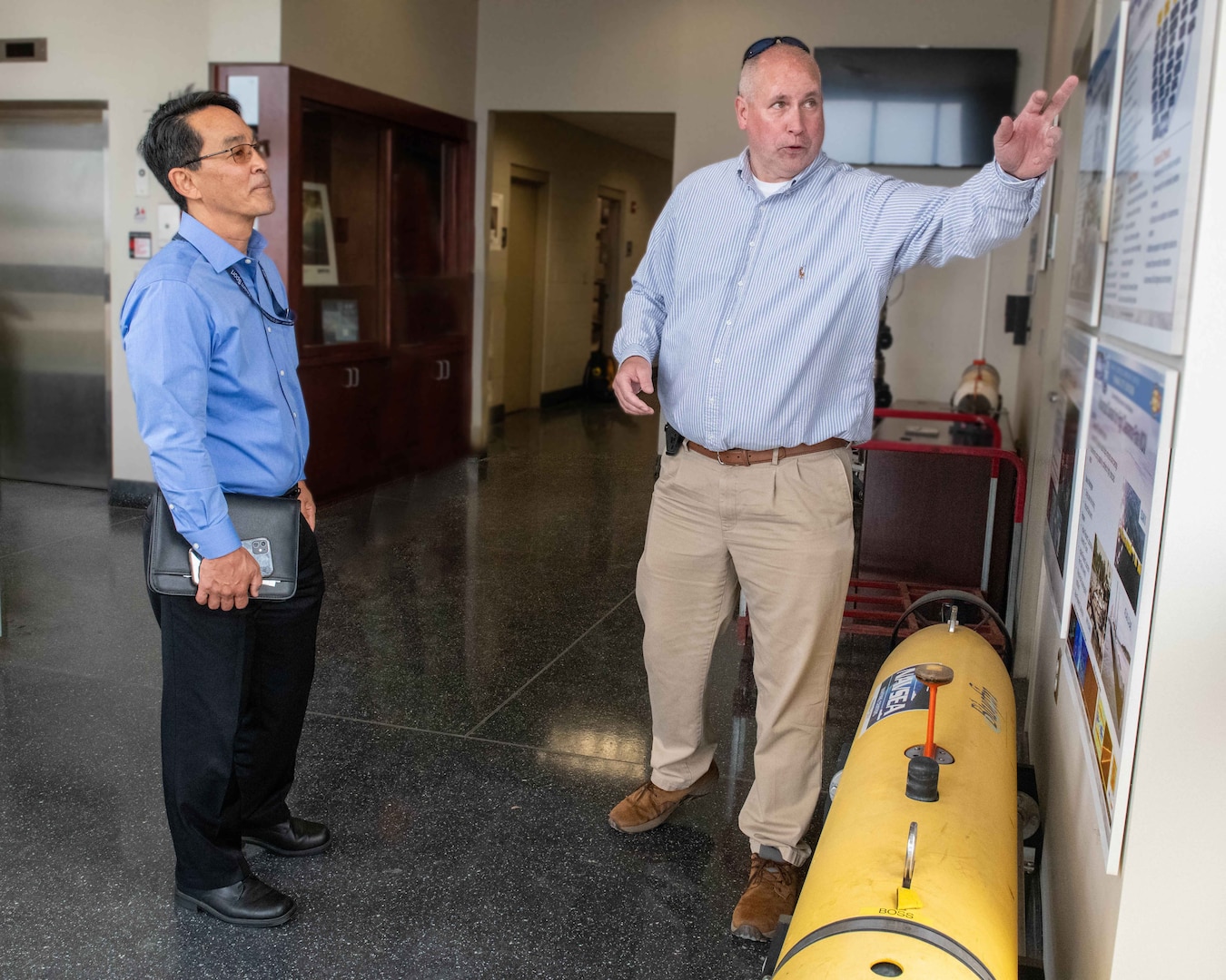 (right) Dan Kucik, NSWC PCD Unmanned Systems distinguished engineer, provides Mr. Jeffrey Koe with an overview of this Navy lab’s more than 60-year history in developing and fielding unmanned systems at NSWC PCD’s Littoral Warfare Research Complex, April 30. (U.S. Navy photo by Eddie Green)