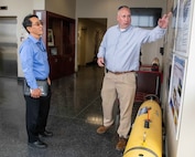 (right) Dan Kucik, NSWC PCD Unmanned Systems distinguished engineer, provides Mr. Jeffrey Koe with an overview of this Navy lab’s more than 60-year history in developing and fielding unmanned systems at NSWC PCD’s Littoral Warfare Research Complex, April 30. (U.S. Navy photo by Eddie Green)