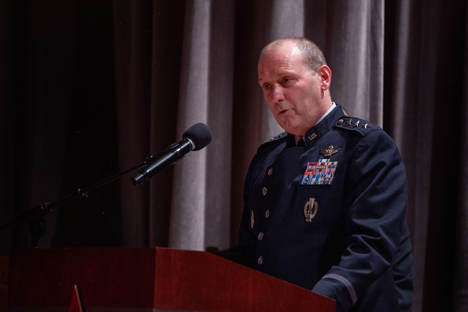 A man in uniform speaks at a podium.