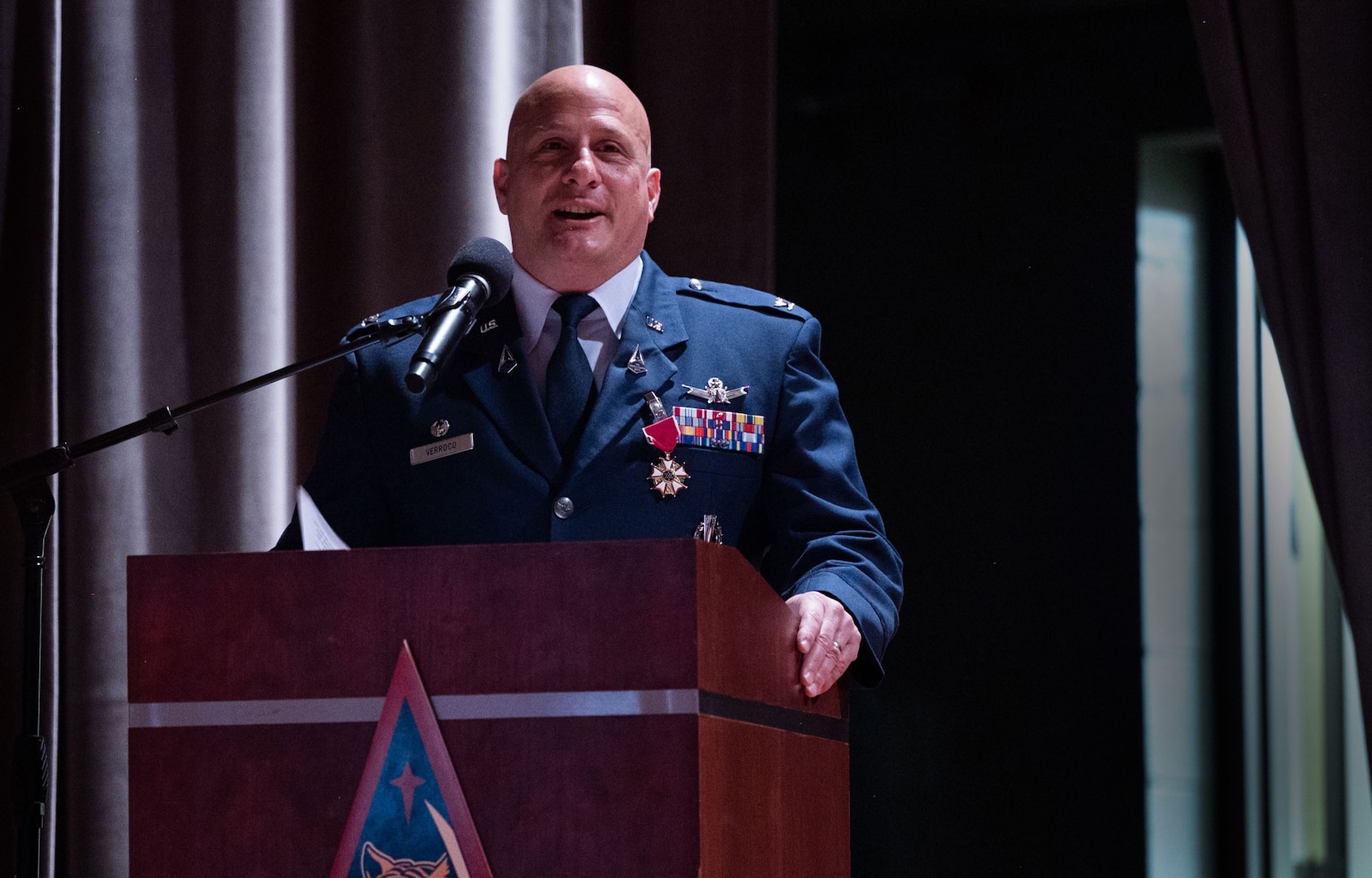 A man in uniform speaks at a podium.