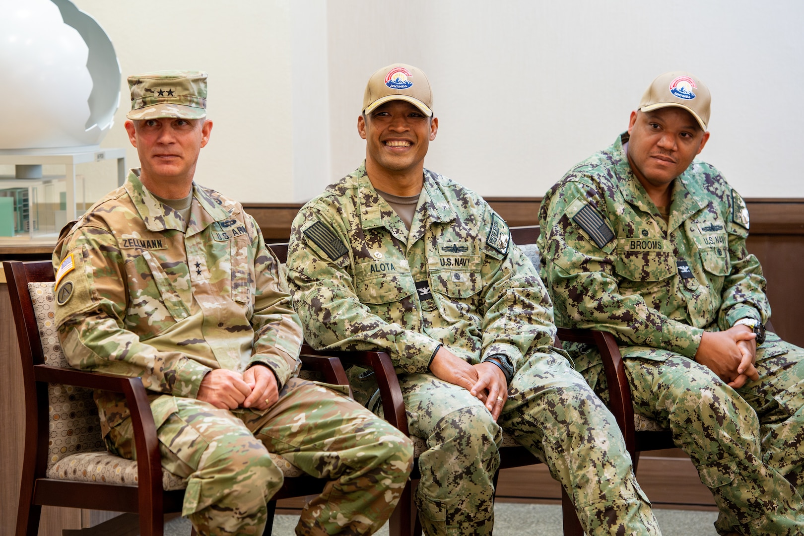 Three male military members sitting in chairs next to each other