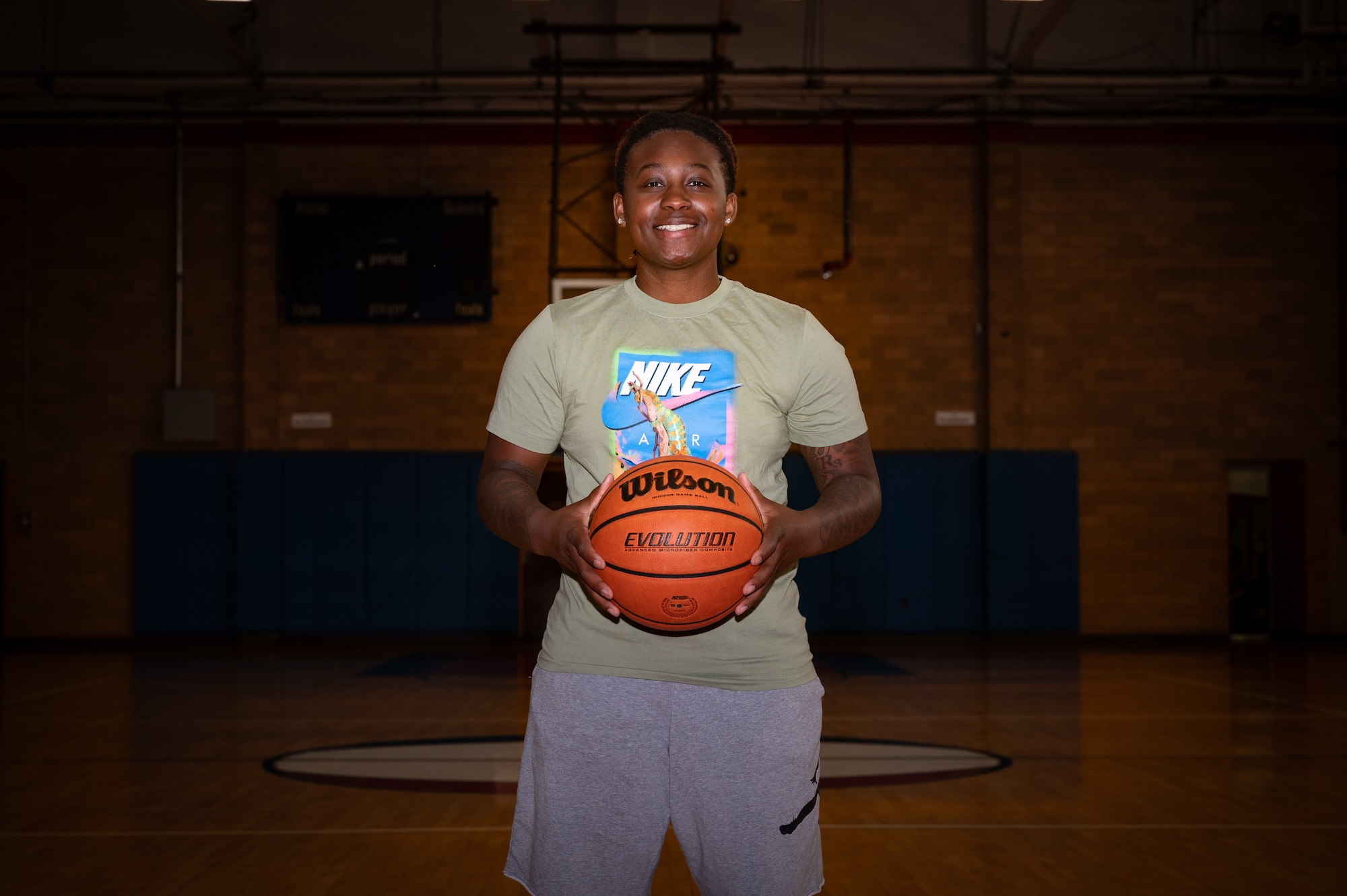 Woman poses for photo with a basketball in hand.