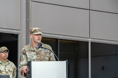 Uniformed member stands at podium and gives a speech.