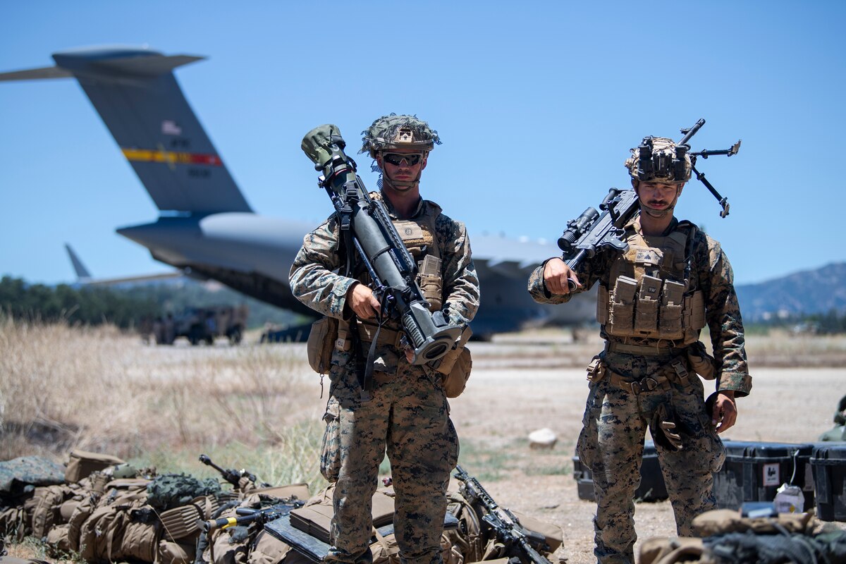 U.S. Marine Corps Cpl. Anthony Salim, left, V17 Suicide Charley Company machine gun leader, and USMC Cpl. James Linder, right, V17 Suicide Charley Company MAAWS gunner, pose for a photo during Exercise STORM CROW at Schoonover Airfield, Jolon, California, June 26, 2024.