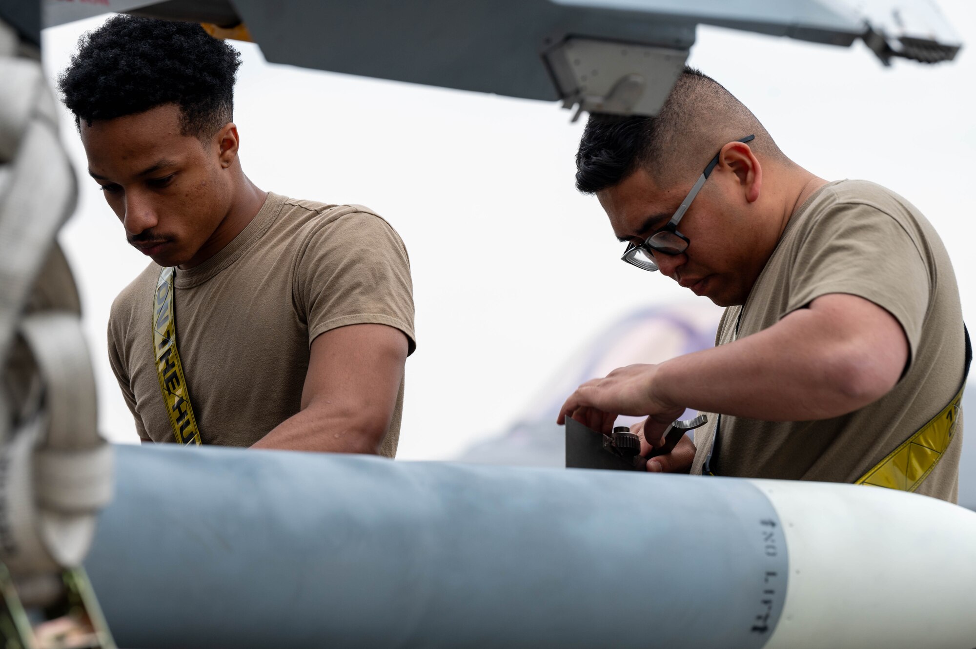U.S. Air Force Airman 1st Class Christian Slade (left), 18th Fighter Generation Squadron load crew team member, and Staff Sgt. Joseph Naehu, 18th FGS load crew team chief, prepare munitions for loading during a load competition at Eielson Air Force Base, Alaska, July 3, 2024.