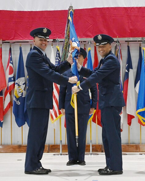 Brig. Gen. Mark Massaro passes the 96th Test Wing guidon to Col. Michael Brough, at the change of command ceremony inside the McKinley Climatic Lab at Eglin Air Force Base, Fla., July 3, 2024.