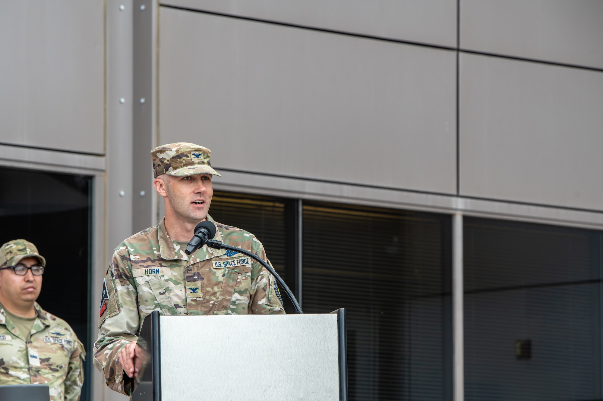 Uniformed member stands at podium and gives a speech.