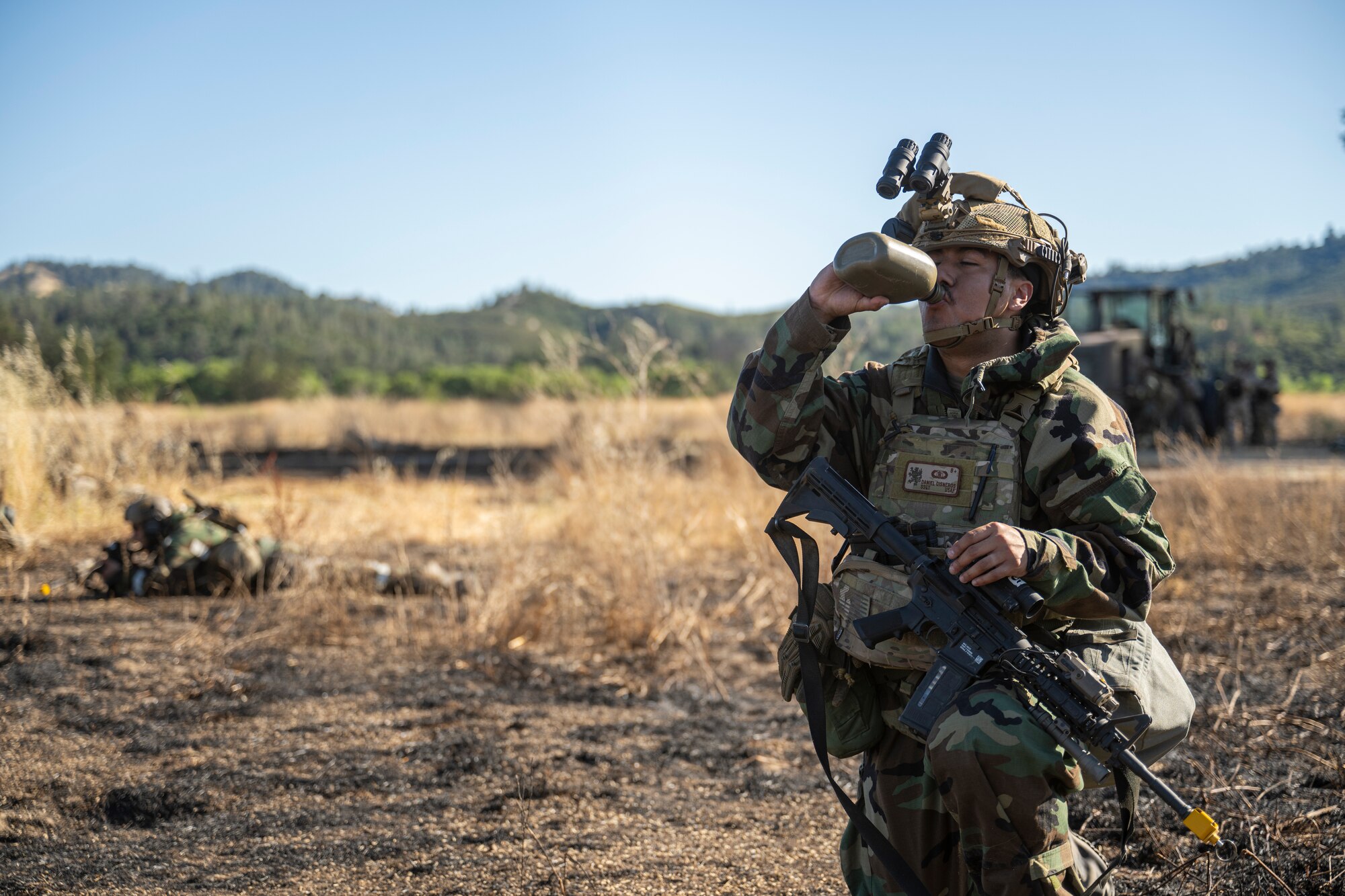 U.S. Air Force Staff Sgt. Daniel Cisneros, 321st Contingency Response Squadron weather technician, drinks water from a canteen during Exercise STORM CROW, at Fort Hunter-Liggett, California, June 26, 2024.