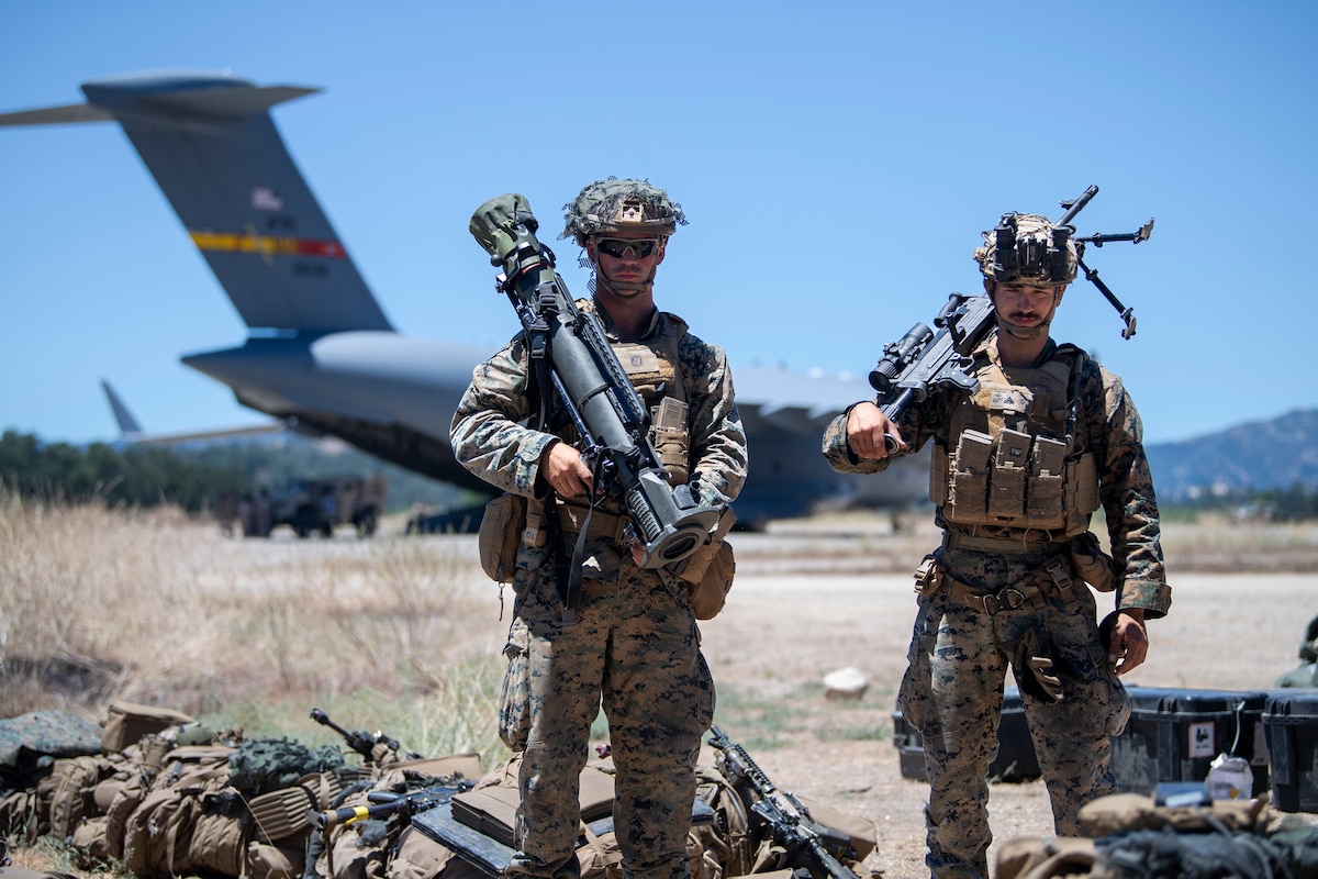 U.S. Marine Corps Cpl. Anthony Salim, left, V17 Suicide Charley Company machine gun leader, and USMC Cpl. James Linder, right, V17 Suicide Charley Company MAAWS gunner, pose for a photo during Exercise STORM CROW at Schoonover Airfield, Jolon, California, June 26, 2024.