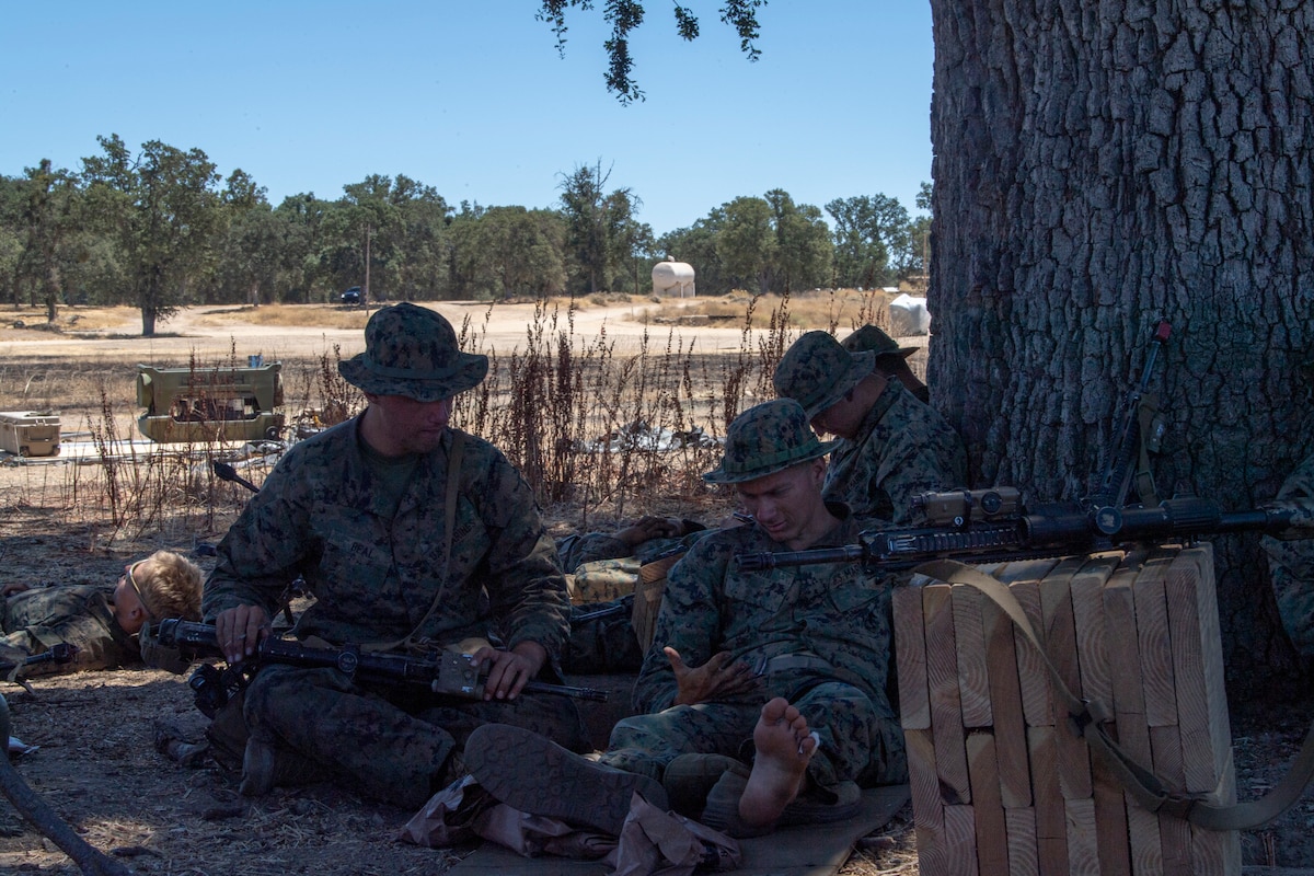 U.S. Marine Corps Marines with V17 Suicide Charley Company find comfort and rest underneath a tree amidst a long flight delays during Exercise STORM CROW at Schoonover Airfield, Jolon, California, June 26, 2024.