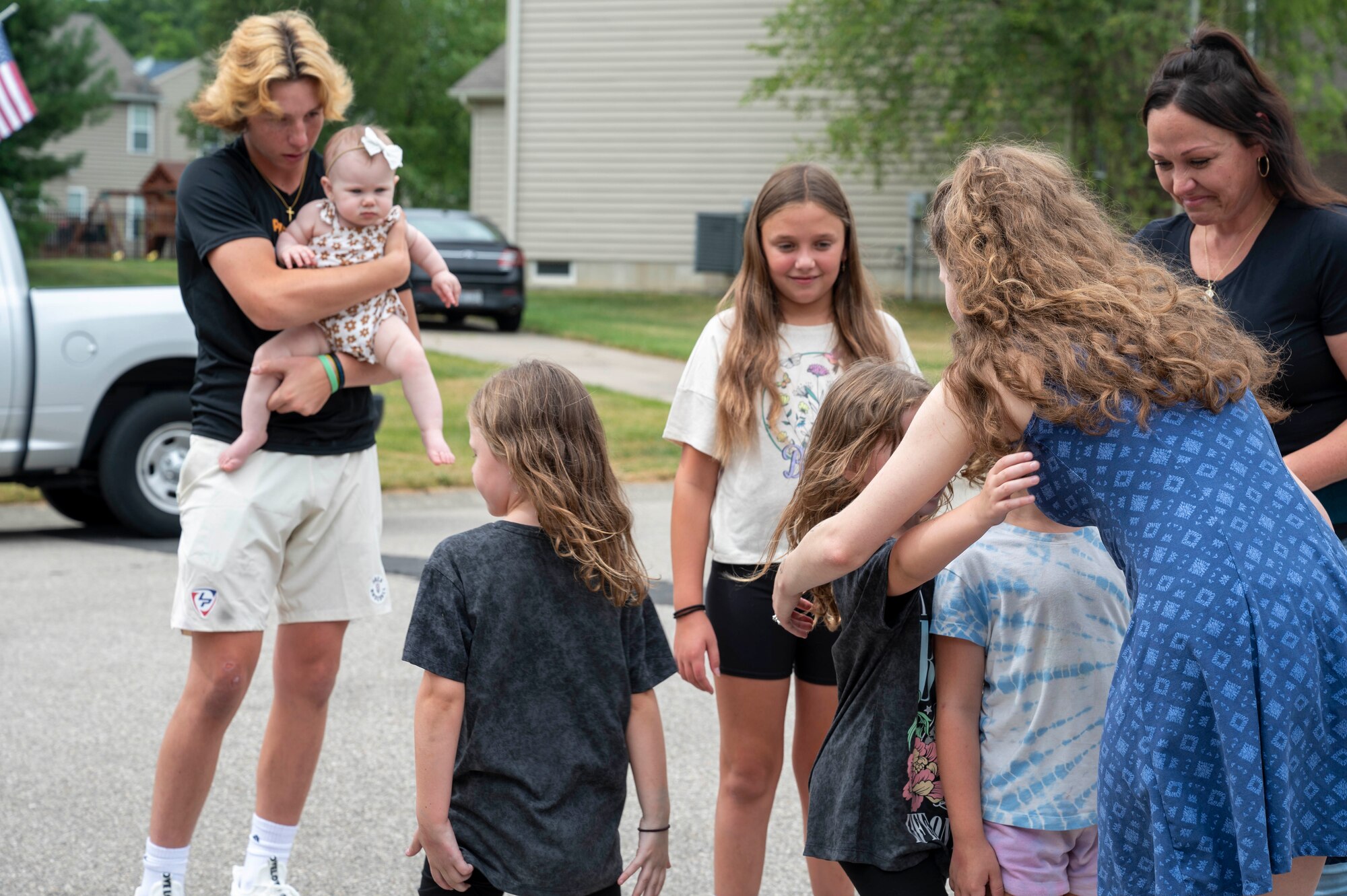 Senior Airman Alexia Archuleta, assigned to the National Air and Space Intelligence Center, but is currently serving on the Wright-Patterson Air Force Base Honor Guard, hugs one of the Fox family children after meeting with the family in Maineville, Ohio, June 26, 2024. Archuleta and her husband were heading home from a friend’s house when they realized a home down the street had caught on fire. The duo saved the life of six people and a dog inside the house. (U.S. Air Force photo by Staff Sgt. Mikaley Kline)