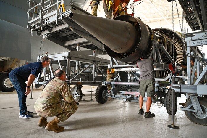 Ryan McGinley, General Electric Military Field Service Representative for Joint Base San Antonio-Lackland, and Senior Master Sgt. Sean Preston, 433rd Maintenance Squadron propulsion flight chief, ensure a General Electric F-138 jet engine is properly seated in its carrier cradle after being lowered from a C-5M Super Galaxy at JBSA-Lackland, Texas June 28, 2024.
