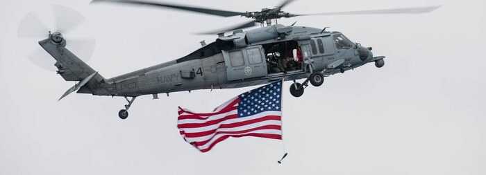 An MH-60 Sea Hawk, assigned to the “Black Knights” of Helicopter Sea Combat Squadron (HSC) 4, flies by the aircraft carrier USS Ronald Reagan (CVN 76).