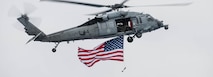 An MH-60 Sea Hawk, assigned to the “Black Knights” of Helicopter Sea Combat Squadron (HSC) 4, flies by the aircraft carrier USS Ronald Reagan (CVN 76).