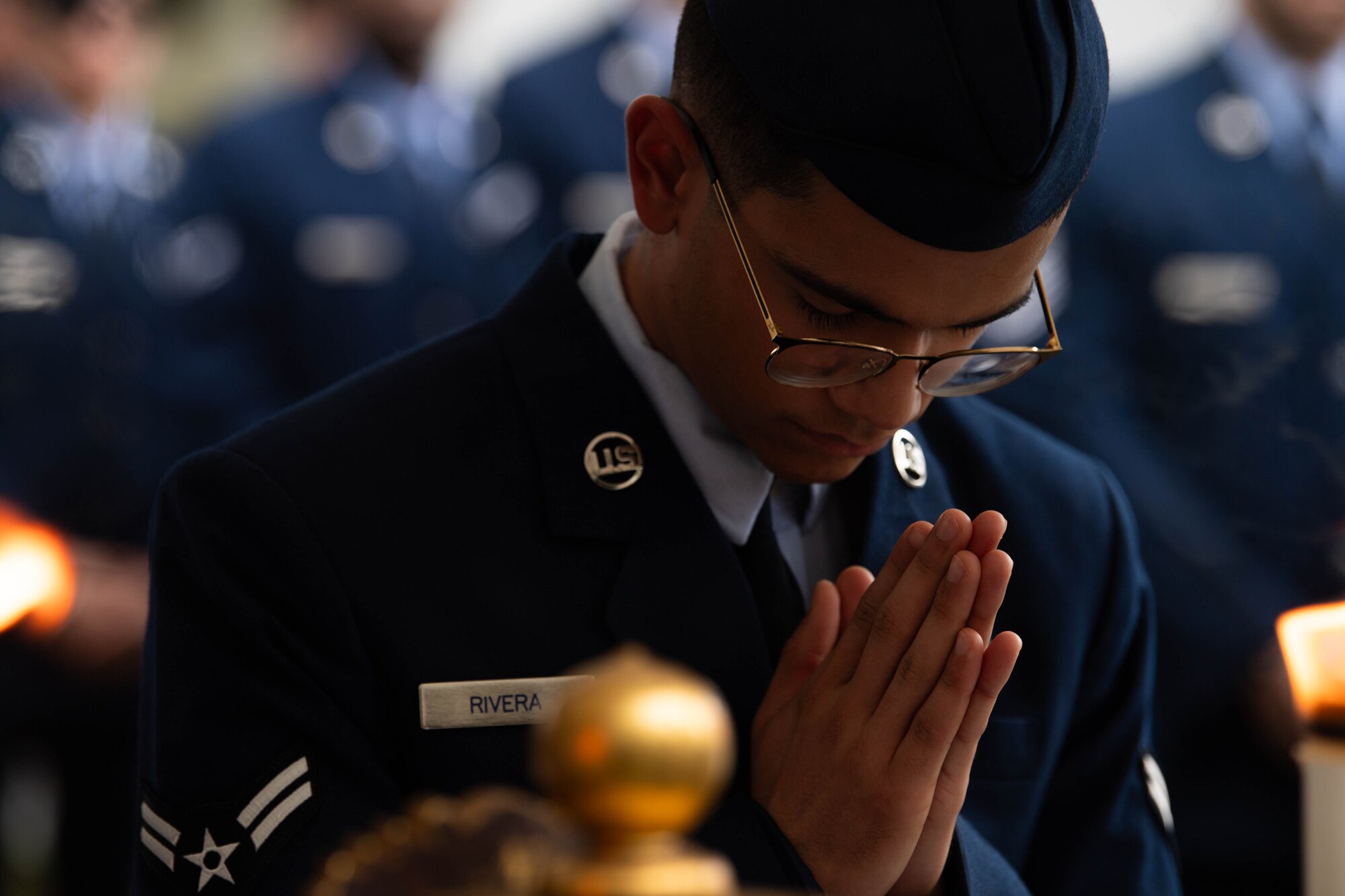 An Airman prays before an incense offering.
