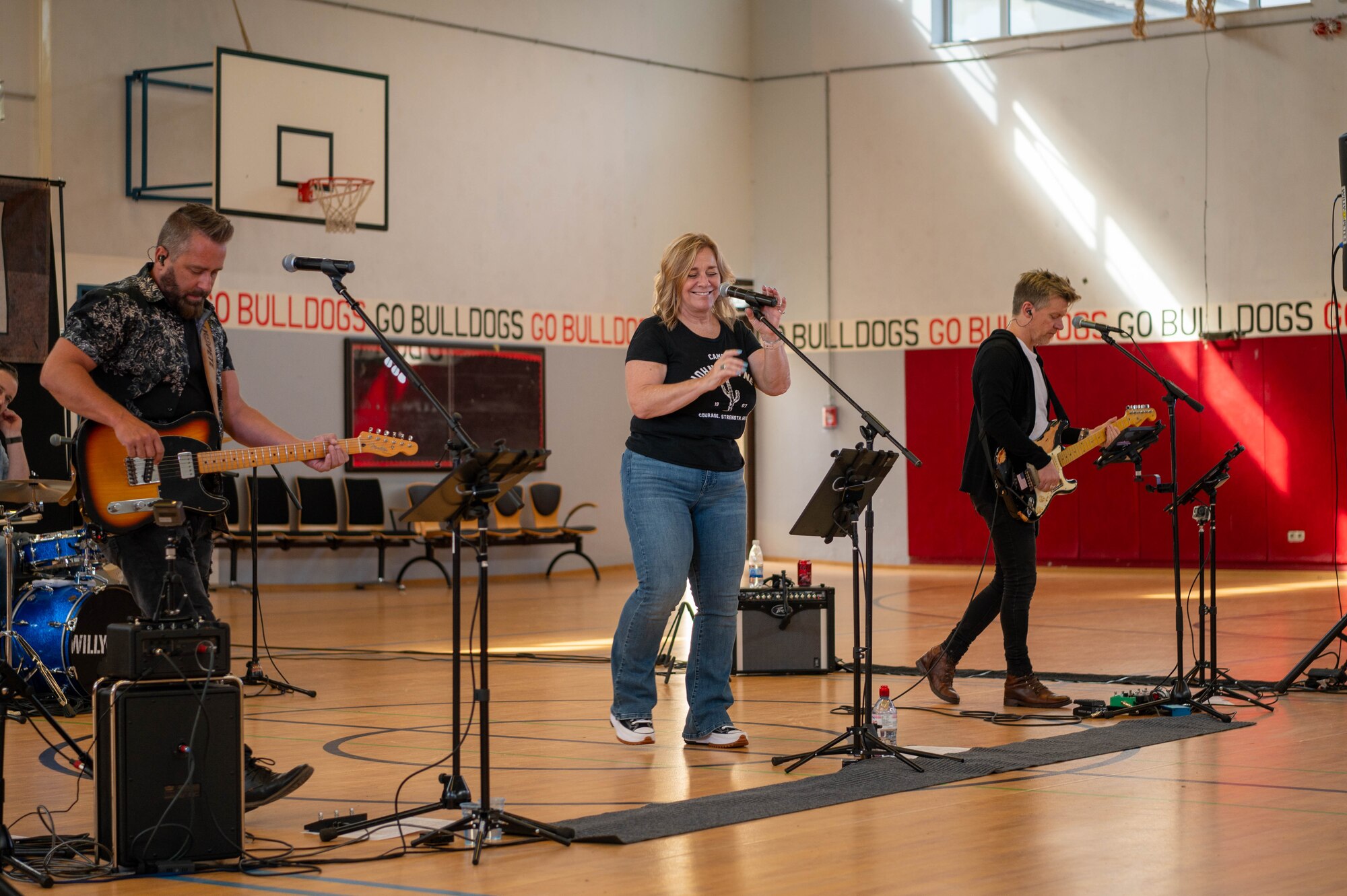 A group of musicians sing and play instruments.
