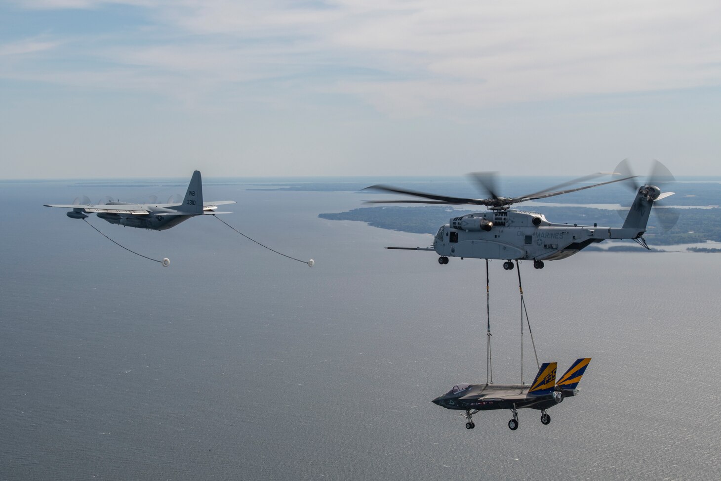 U.S. Marines from VMX-1 pilot a CH-53K helicopter over the Chesapeake River in Maryland, conducting aerial refueling from a C-130T operated by U.S. Navy’s VX-20 while carrying a non-flying F-35C test airframe from the NAS Patuxent River F-35 Integrated Test Force on April 23, 2024. The flight was conducted in preparation for the aerial transport of the non-flying F-35C airframe from NAS Patuxent River, MD, to Joint Base McGuire-Dix-Lakehurst, NJ, the following day.