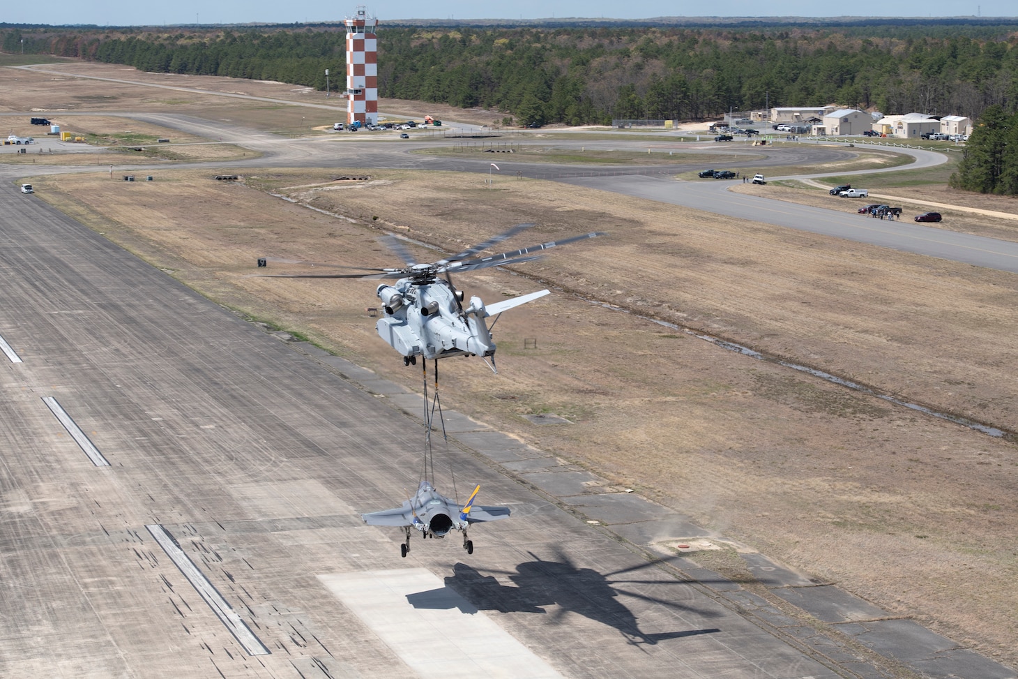 U.S. Marine Corps pilots from VMX-1 flying a CH-53K helicopter lower a non-flying F-35C airframe from the NAS Patuxent River F-35 Integrated Test Force onto the runway at Joint Base McGuire-Dix-Lakehurst, NJ, on April, 24, 2024, after transporting the F-35C airframe from NAS Patuxent River, MD. The transportation of the airframe will enable future testing at Lakehurst of emergency recovery systems.