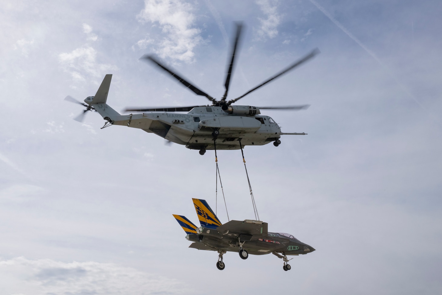 A CH-53K piloted by U.S. Marines from VMX-1 hoists a non-flying F-35C from the NAS Patuxent River F-35 Integrated Test Force April 24, 2024, to transport the airframe from NAS Patuxent River, MD, to Joint Base McGuire-Dix-Lakehurst, NJ, where the airframe will be used in future emergency recovery systems testing. The successful operation was coordinated and carried out through extensive collaboration of multiple teams across NAS Patuxent River, JB McGuire-Dix-Lakehurst, the U.S. Marine Corps, the U.S. Navy, New Jersey State Police, and NAWCAD.