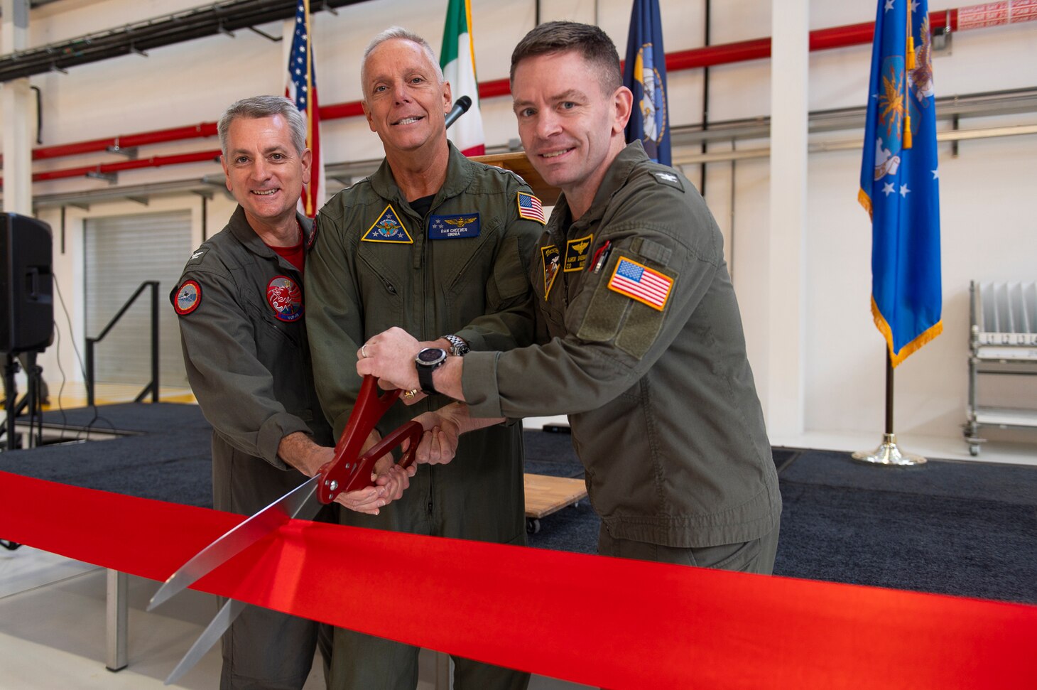 Capt. Ronald H. Rumfelt Jr., commanding officer, Unmanned Patrol Squadron (VUP) 19 "Big Red" (left), Vice Adm. Daniel “Undra” Cheever, Commander, Naval Air Forces (center), and Capt. Aaron Shoemaker, commanding officer, Naval Air Station (NAS) Sigonella (right), participate in a ribbon cutting ceremony to celebrate the inaugural deployment of VUP- 19's second forward-deployed detachment, and the opening of a new MQ-4C Triton hangar at NAS Sigonella, Italy, March 2, 2024. VUP- 19 is the first and only unmanned patrol squadron and will set a baseline for training Sailors and officers on the tactics, techniques and procedures of operating the MQ-4C Triton for future warfighting.