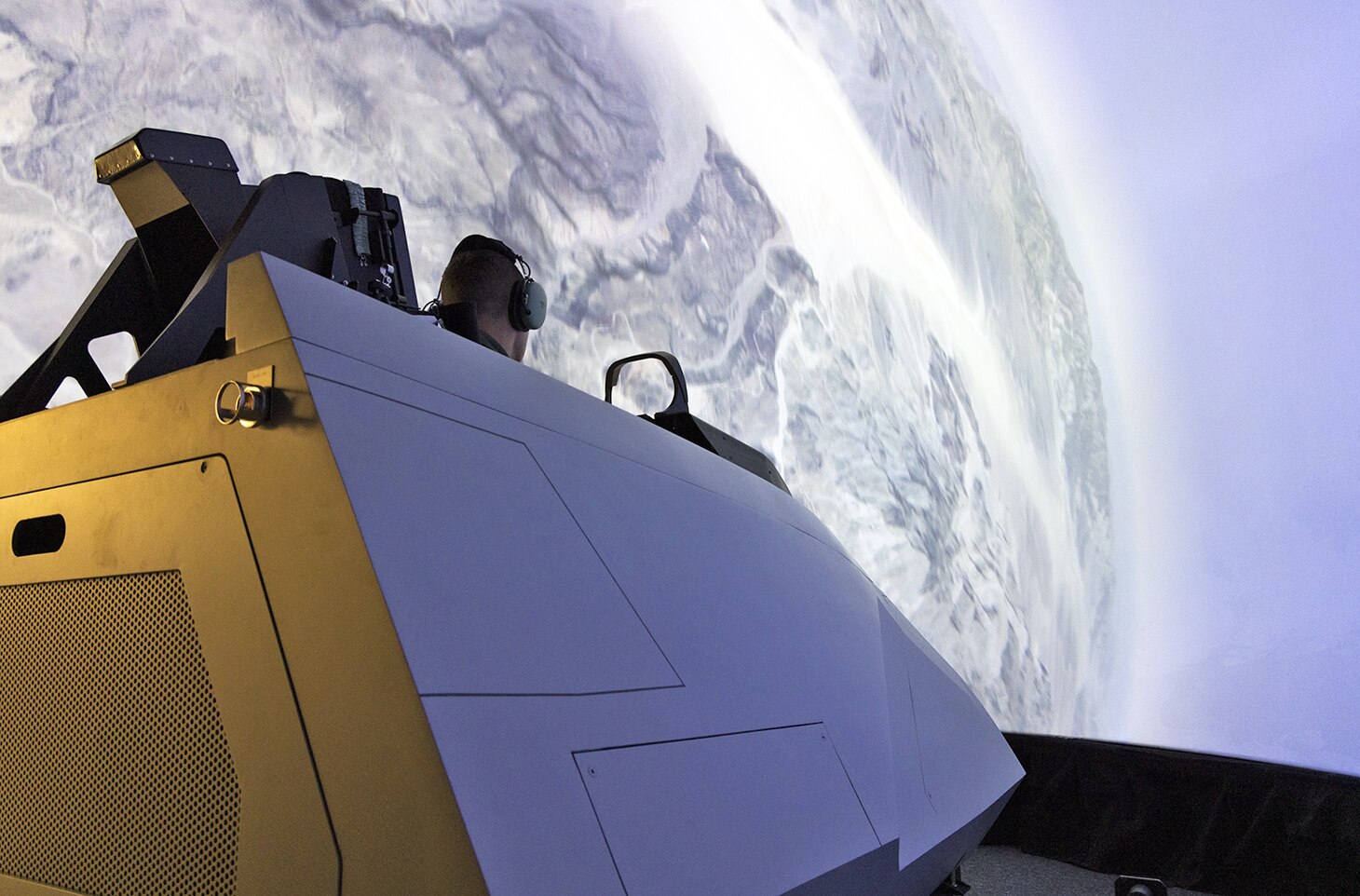 A pilot tests a U.S. Air Force F-22 Raptor cockpit simulator headed for installation in the Naval Air Warfare Center Aircraft Division’s Joint Simulation Environment. The Navy installed a division of four Raptor cockpits alongside a division of eight F-35 Lightning cockpits in its advanced tactical trainer so Navy and Air Force fighter pilots can train as a joint force starting in 2024.