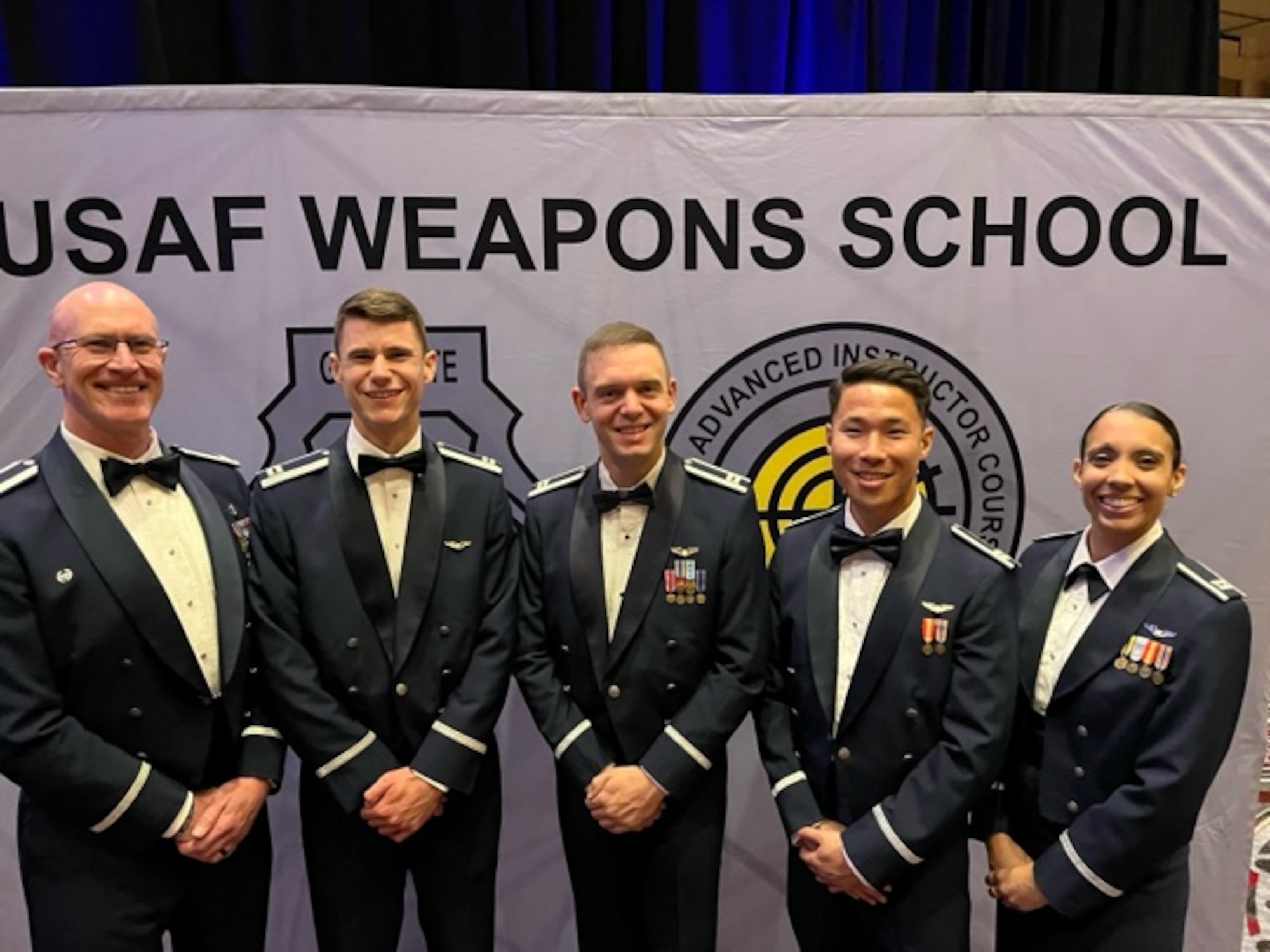 Five Airmen pose for a photo.