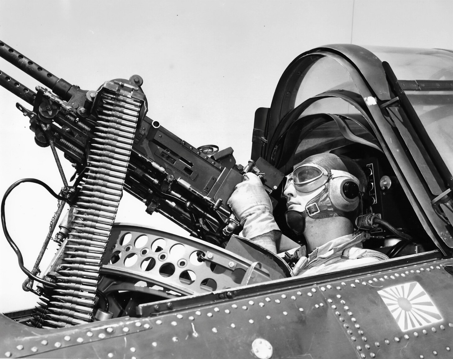 The rear-seat gunner of an SBD dive bomber could have a single, or in this case, two .30 caliber machine guns (later in the war) to defend his aircraft and others in his formation. Note the single Japanese kill flag below him. Coordination and dependability were the hallmarks of these two-man crews.